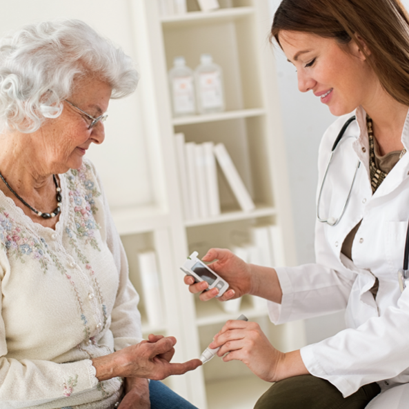 phlebotomist using finger prick test on older woman