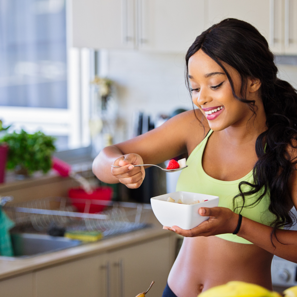 Pretty athletic black woman eating fruits