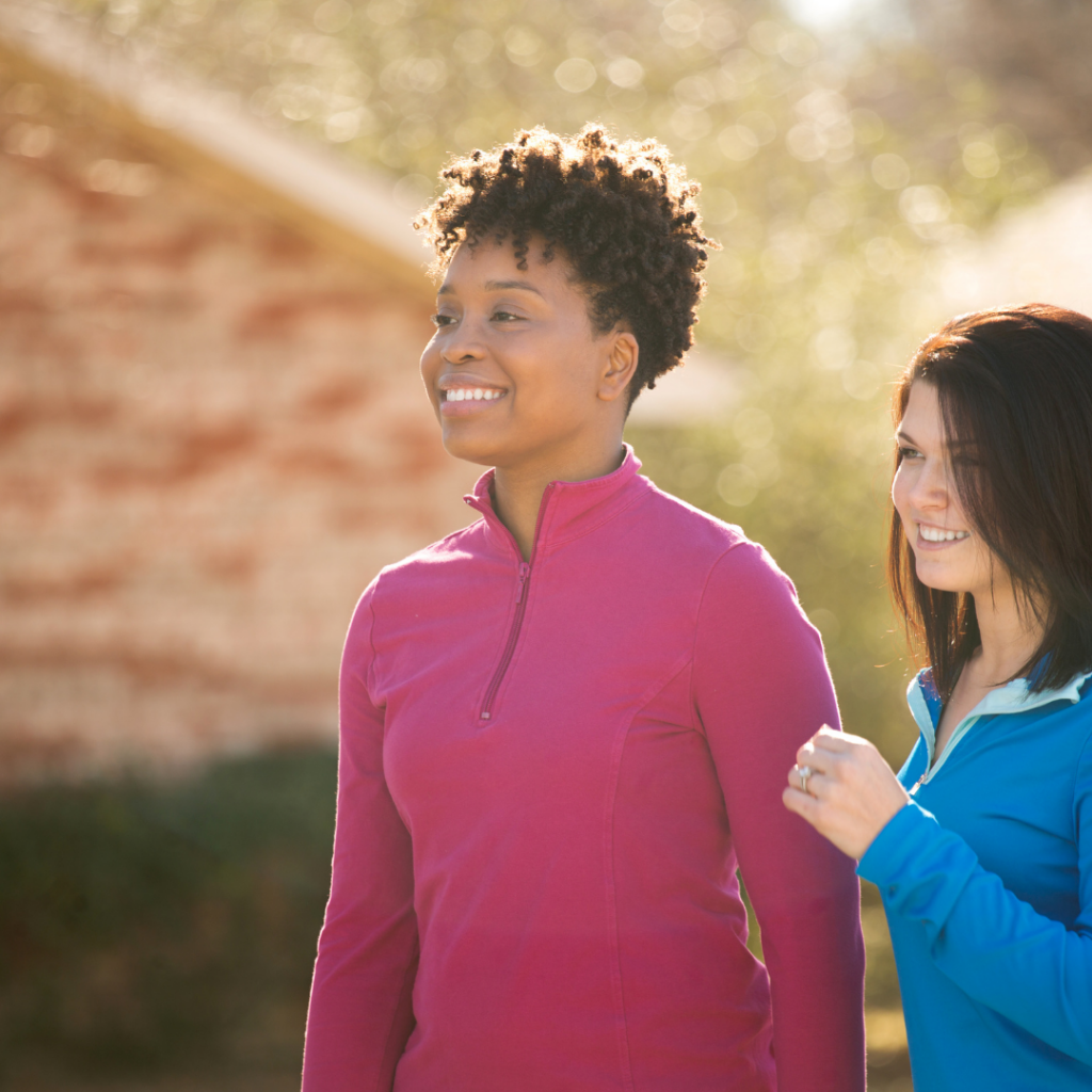Two happy woman talking a walk together.