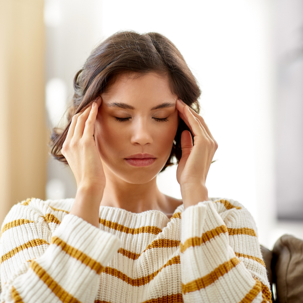 Woman rubbing her temples trying to reduce her stress