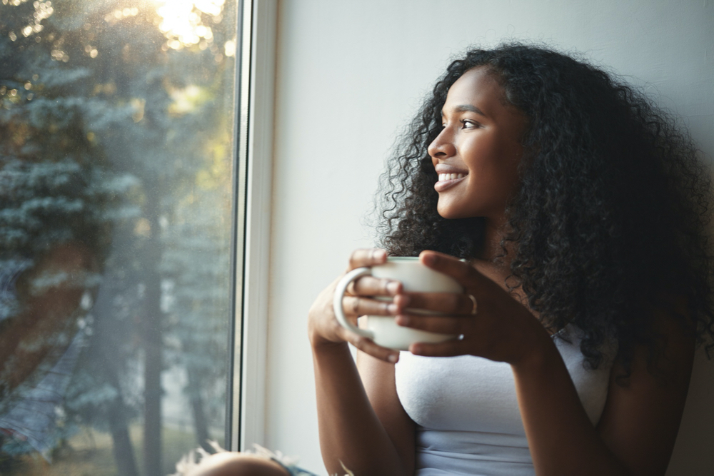 Morning routine. portrait of happy charming young mixed race female with wavy hair enjoying summer 