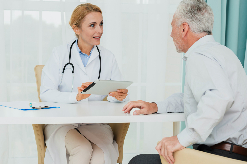 photo doctor talking to patient while holding tablet