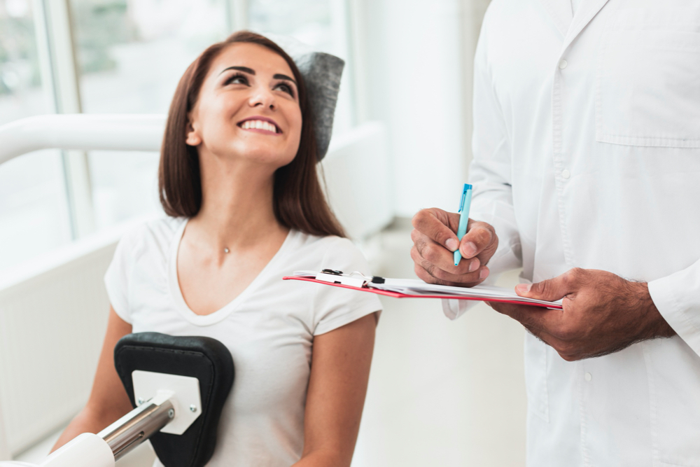 photo smiling female patient looking at doctor
