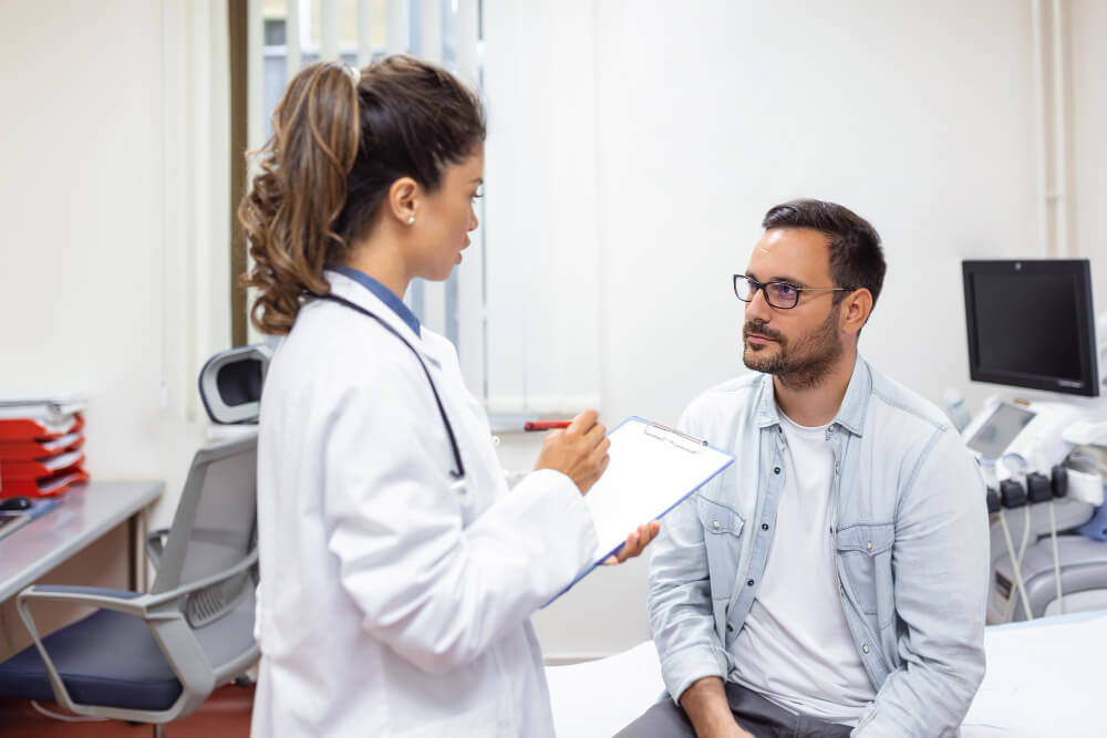 man consulting with doctor at checkup meeting in hospital