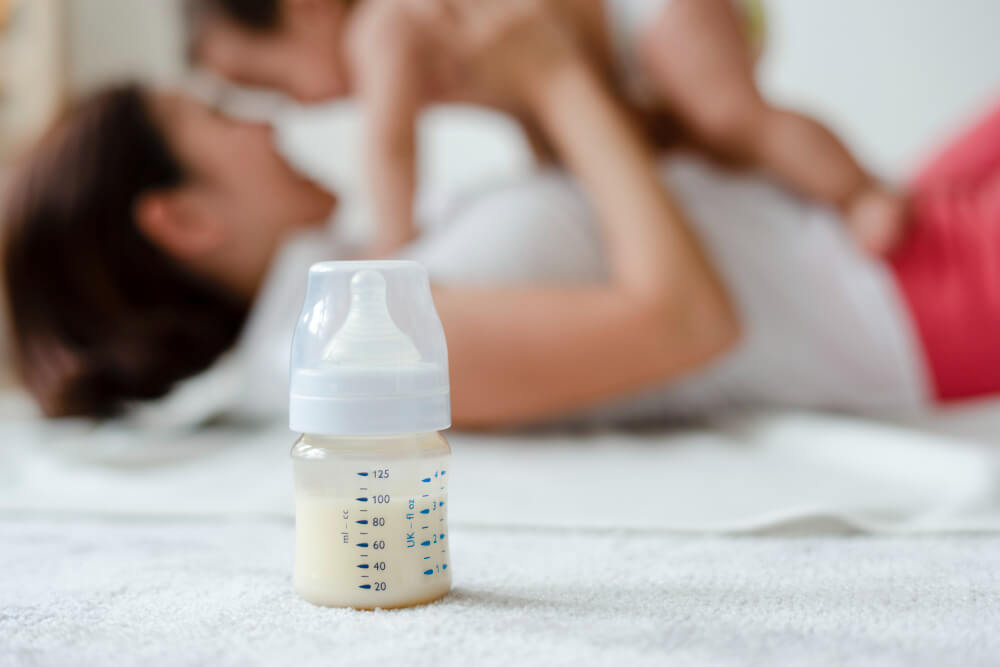 Baby formula with mom and baby in the background
